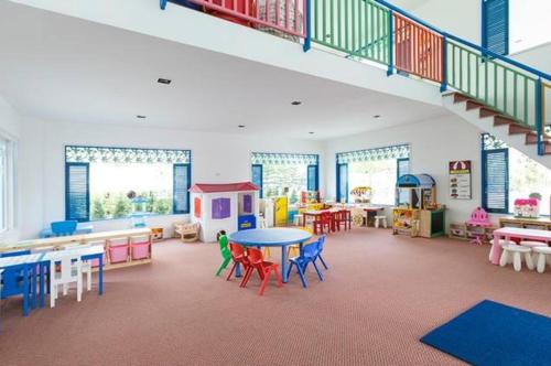 a play room with tables and chairs and a staircase at My Resort at Hua Hin by Charma in Hua Hin