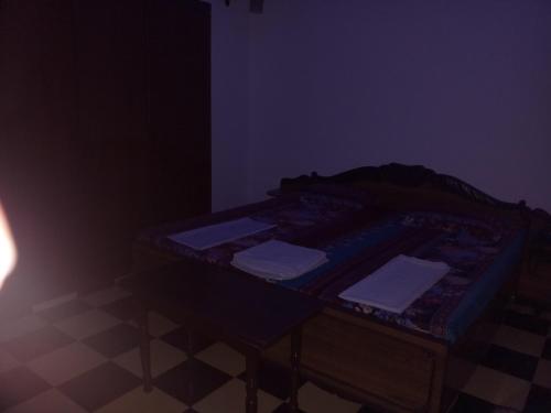 a dark room with a bed in a dark room at Sai Palace in Agra