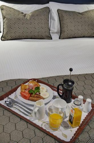 a tray of breakfast food on a bed at CBD Motor Inn in Coffs Harbour