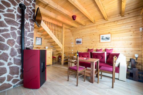 a room with a table and chairs in a log cabin at Holiday homes Piralo in Kostajnica
