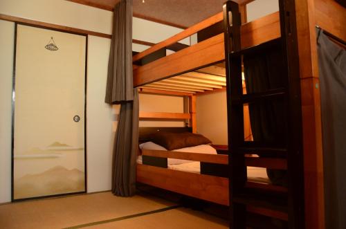 - une chambre avec 2 lits superposés et une porte coulissante en verre dans l'établissement Peace house Abeno, à Osaka