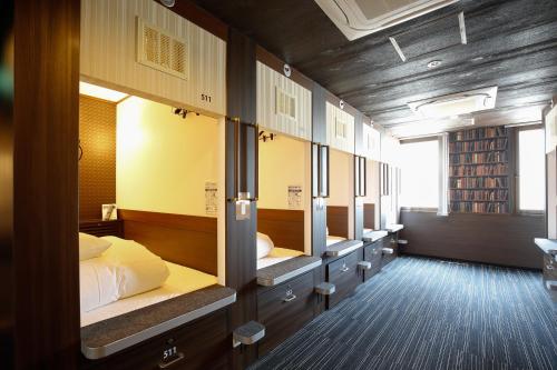 a row of bunk beds in a room at Sejour Inn Capsule in Hiroshima