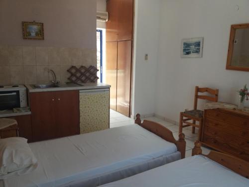 a room with two beds and a kitchen with a sink at Galini view in Frý
