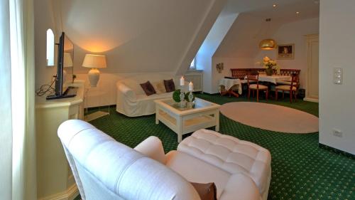 a living room with a couch and a table at Boutique Hotel POST ANDECHS in Andechs
