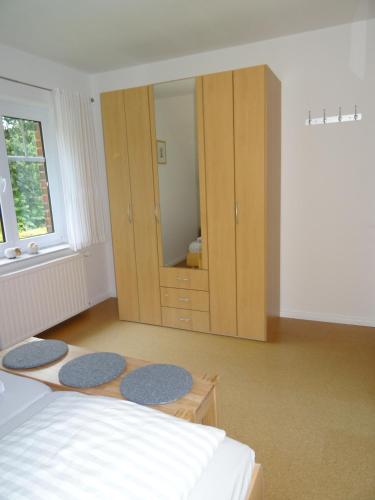 a bedroom with a bed and a cabinet and two rugs at Bei Ute und Peter in Westerstede
