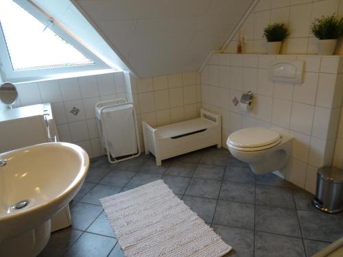 a bathroom with a sink and a toilet and a window at Bei Ute und Peter in Westerstede