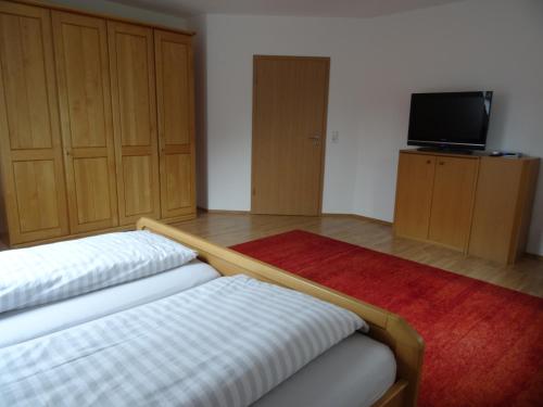 a living room with a bed and a tv and cabinets at Bei Ute und Peter in Westerstede