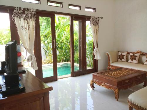 a living room with a tv and a couch and a table at Villa das Meer 2BR Villa near Lovina Beach in Lovina