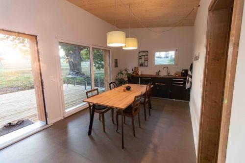 a kitchen and dining room with a wooden table and chairs at Au Chant du Vent in Tramelan