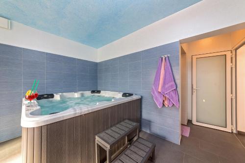 ein Badezimmer mit einer Badewanne und einer violetten Decke in der Unterkunft Villa Petra, Kaštelir in Kaštelir