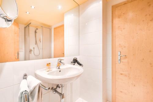 La salle de bains est pourvue d'un lavabo et d'une douche. dans l'établissement Rosa Canina Superior, à Sankt Anton am Arlberg