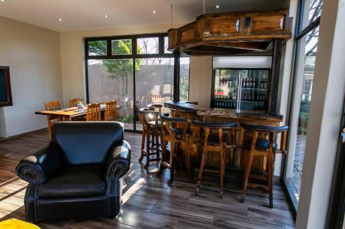 a bar in a restaurant with chairs and tables at Royl Court Guesthouse in Kimberley