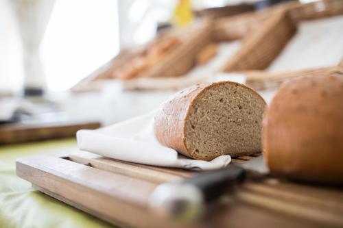 a loaf of bread on a cutting board with a knife at Der WALZL in Innsbruck
