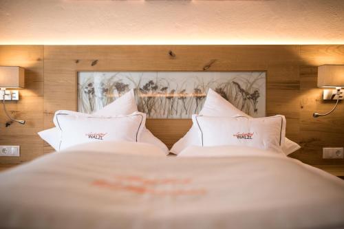 a bedroom with a bed with white pillows at Der WALZL in Innsbruck