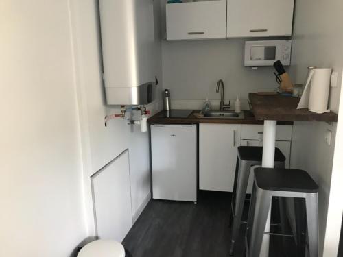 a small kitchen with white cabinets and a counter at Studio indépendant très calme in Saint-Jean-de-Védas