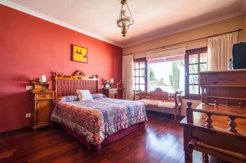 a bedroom with red walls and a bed and a window at Magnífica Villa al lado del mar in Arrecife
