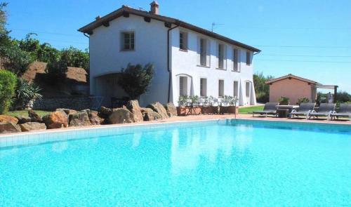 a large swimming pool in front of a house at La Chiusa di Rio in Rio nellʼElba