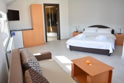 a bedroom with a bed and a couch and a table at Deltix Apartments in Vršac
