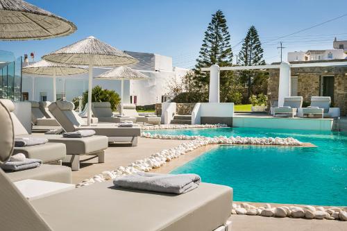 a pool with chaise lounge chairs and a swimming pool at Ilio Maris in Mýkonos City