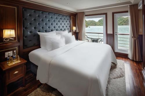 a large white bed in a room with a window at Paradise Elegance Cruise Halong in Ha Long