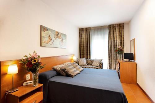 une chambre d'hôtel avec un lit et un canapé dans l'établissement Hotel Corolle, à Florence