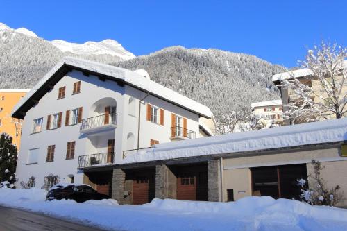 a building covered in snow with a mountain in the background at Chalet Cuore delle Alpi in Airolo