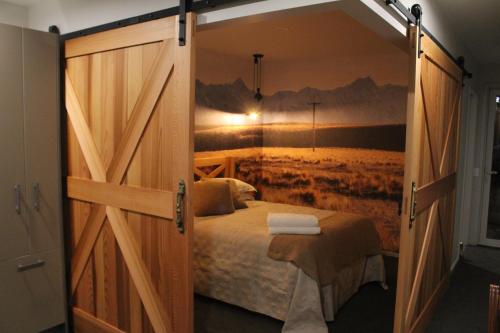 a bedroom with a bed and a painting on the wall at The Mackenzie Suites in Lake Tekapo