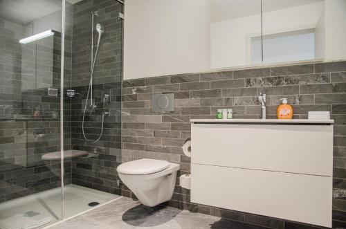 ein Bad mit einem WC und einer Glasdusche in der Unterkunft Apartment JungfrauCenter Bällenhöchst - GriwaRent AG in Interlaken