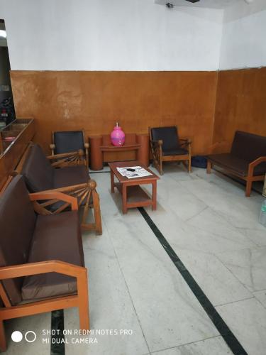 a waiting room with chairs and a table and a pink vase at GP Mansion in Chennai