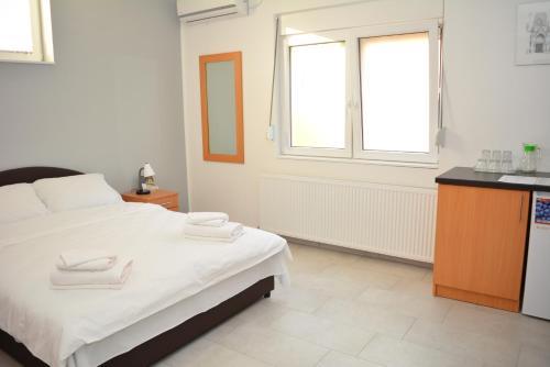 a bedroom with a bed with two towels on it at Deltix Apartments in Vršac