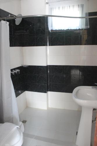a black and white bathroom with a toilet and a sink at Veranda Hotel in Paoay