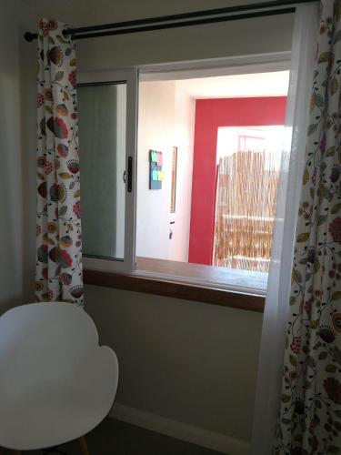 a window in a room with a white chair and a door at Villa Pupunu Dodo a Pereybere in Pereybere