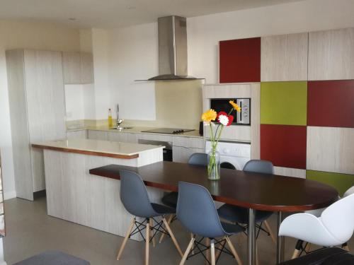 a kitchen with a table with chairs and a vase of flowers at Villa Pupunu Dodo a Pereybere in Pereybere