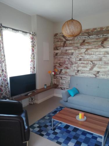 a living room with a blue couch and a tv at Villa Pupunu Dodo a Pereybere in Pereybere