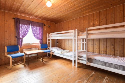 a bedroom with two bunk beds and a desk and chair at Lille Randklev Gæstehus in Ringebu