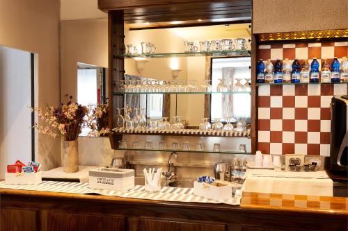 una cucina con bancone, specchio e lavandino di Hotel Corolle a Firenze