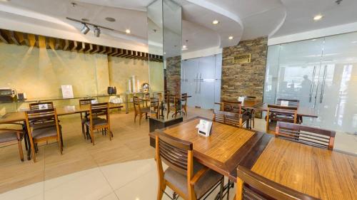 jadalnia z drewnianymi stołami i krzesłami w obiekcie O Hotel w mieście Bacolod