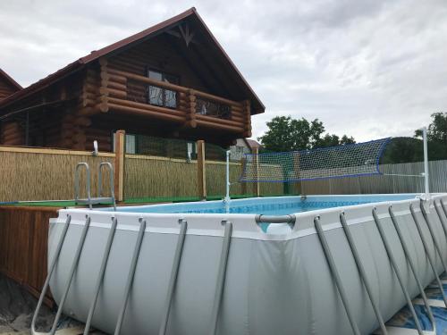 a swimming pool in front of a log house at Smerekovyi Dvir in Polyana
