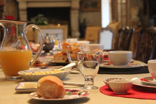 uma mesa com pratos de comida e copos de sumo de laranja em Manoir de Kerliviry em Cléder