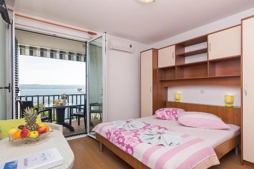 um quarto com uma cama e uma varanda em Apartments Zina em Brela