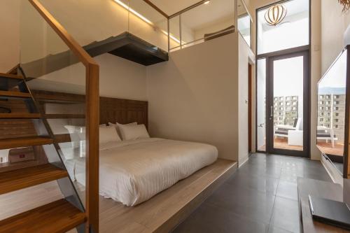 ein Schlafzimmer mit einem Bett und einer Treppe in einem Gebäude in der Unterkunft FomeStay in Chishang