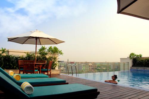 una mujer en la piscina de un hotel en Lemon Tree Premier City Center, en Gurgaon