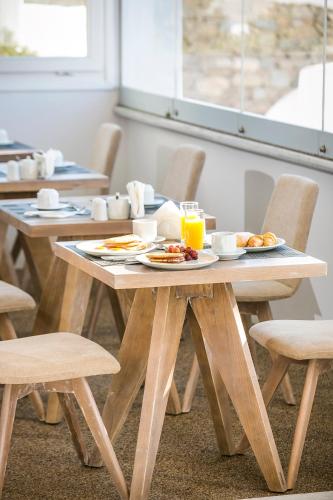 a table with plates of food and orange juice at Ilio Maris in Mýkonos City