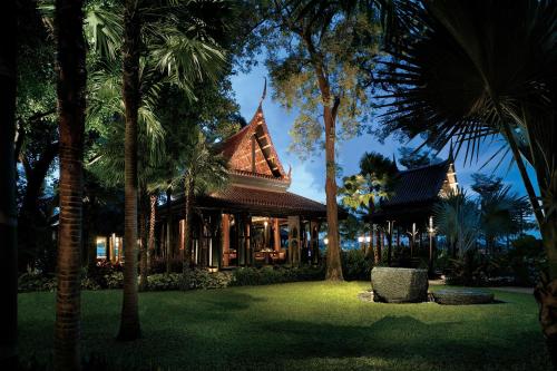 a resort with palm trees in front of a building at Shangri-La Bangkok in Bangkok