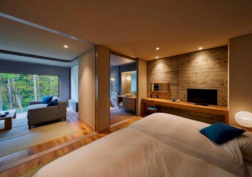 a bedroom with a large bed and a television at Okujozankei Onsen Kasho Gyoen in Jozankei