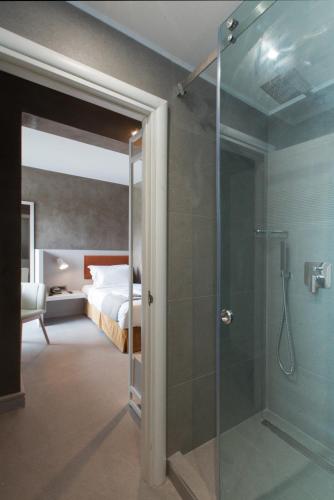 a bathroom with a shower and a bedroom with a bed at Garden City Resort in Kalamata