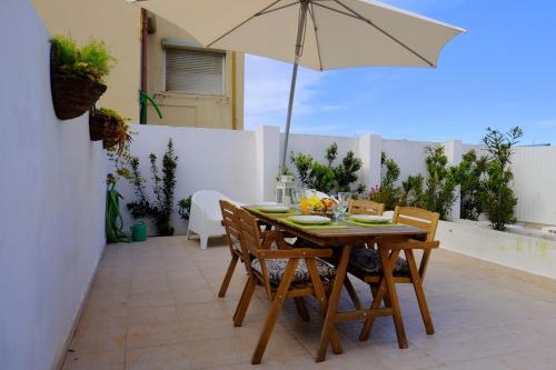 a table and chairs with an umbrella on a patio at Lisbon Lights Apartments in Lisbon