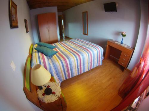 a small bedroom with a bed and a table with a lamp at Hotel El Golobar in Reinosa
