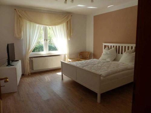 ツィノヴィッツにあるFerienwohnung Zinnowitzのベッドルーム(白いベッド1台、窓付)