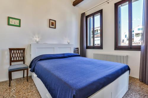een slaapkamer met een bed, een stoel en ramen bij Ca' Dell'Abate Terrace in Venetië